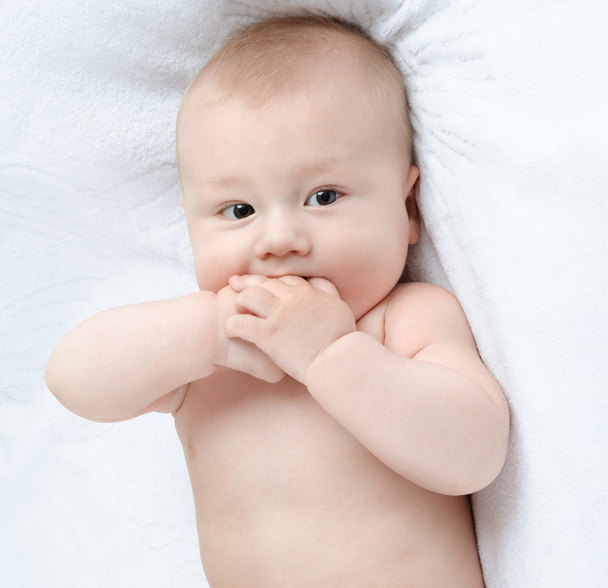 gelukkig baby liggend op een wit tapijt - Foto, afbeelding