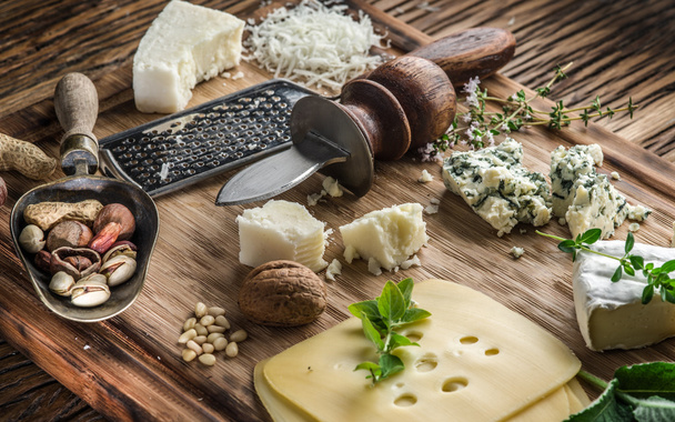 Different types of cheeses with nuts and herbs. - Photo, Image