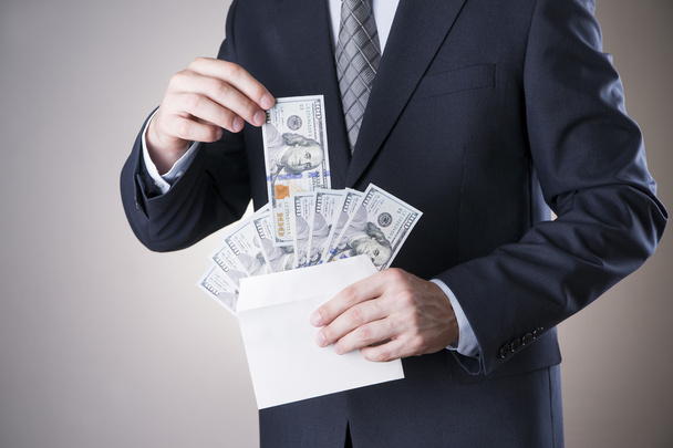 Businessman with money in studio. Corruption concept - Foto, Imagen