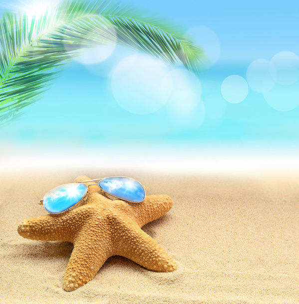  starfish in sunglasses on the sandy beach and palm - Photo, Image
