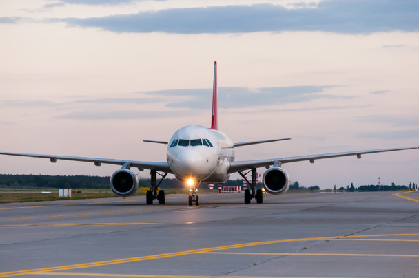 Perspective view of jet airliner at taxiway. Evening scene with travel background - Photo, Image