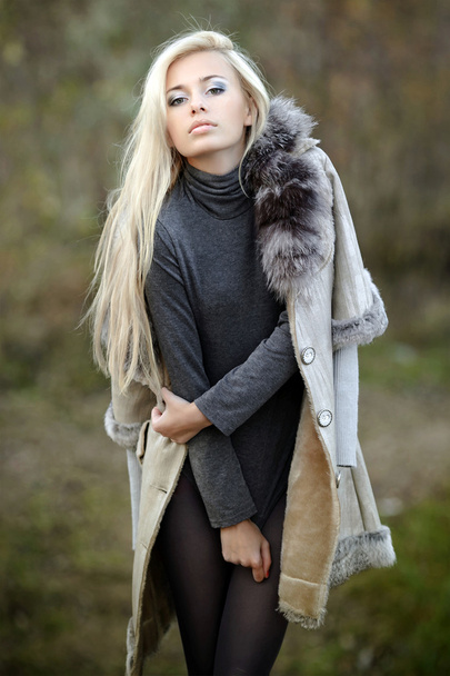 Girl in a fur coat in the autumn background - Fotoğraf, Görsel