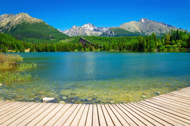 Dřevěné plošině s výhledem na jasné horské jezero  - Fotografie, Obrázek