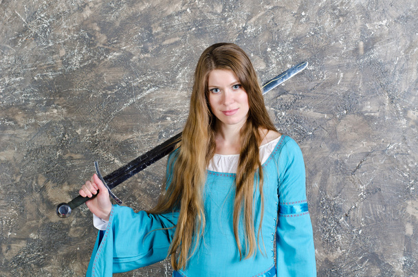 Mladá žena s dlouhými vlasy pózuje s mečem - Fotografie, Obrázek