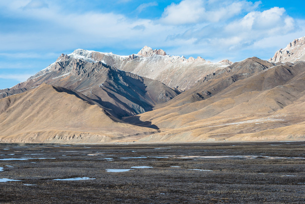 Prachtige Tibetaanse landschap met bevroren meren, besneeuwde bergen en bewolkte hemel - Foto, afbeelding
