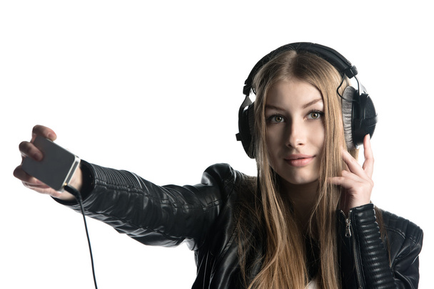 Young model in wired headphones listening music and making selfie - Photo, Image