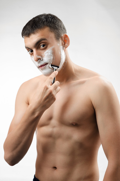 young man shaving with a razor - Fotoğraf, Görsel