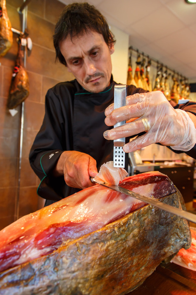 Hombre cortando jamón, jamón iberico
 - Foto, imagen