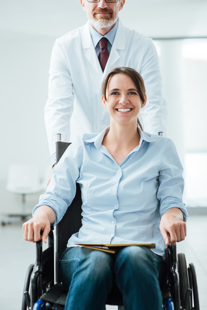 Doctor pushing a patient in wheelchair - Photo, Image