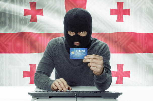 Hacker de piel oscura con bandera sobre fondo con tarjeta de crédito - Georgia - Foto, imagen