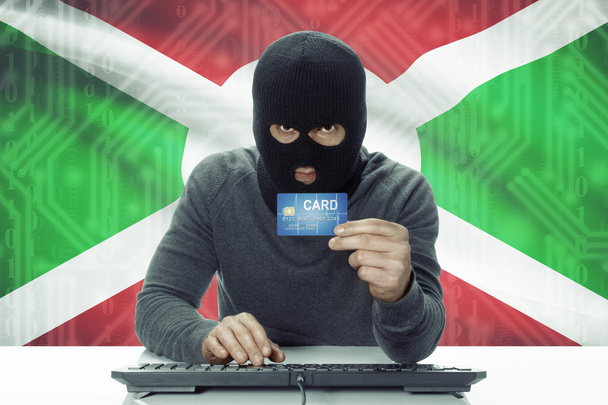 Dark-skinned hacker with flag on background holding credit card - Burundi - Foto, imagen