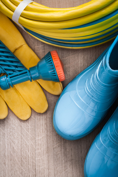 hose with spray nozzle,  gloves and gumboots - 写真・画像