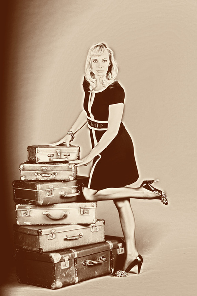Young woman and a lot of old suitcases - Фото, изображение