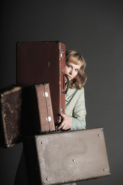 Young woman and a lot of old suitcases - Foto, imagen