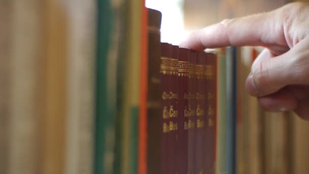 Plank met boeken - nemend een boek uit de bibliotheek - Video