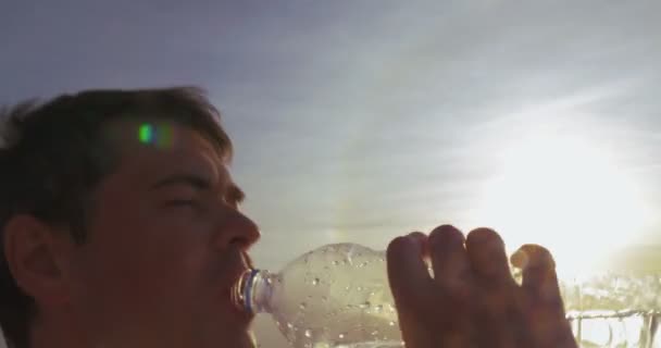 junger Mann trinkt Wasser im Freien bei Sonnenuntergang - Filmmaterial, Video