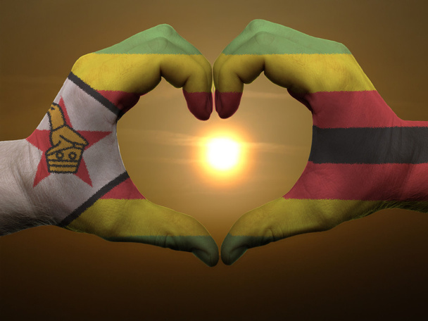καρδιά και αγάπη χειρονομία από χέρια χρωματισμένη με σημαία της Ζιμπάμπουε κατά τη διάρκεια - Φωτογραφία, εικόνα