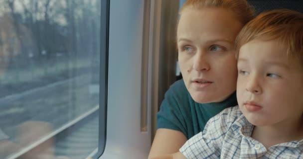 Moeder en zoon kijken uit trein venster - Video