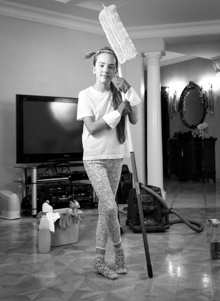 Zwart-wit foto van tiener meisje huis met doekje reinigen - Foto, afbeelding