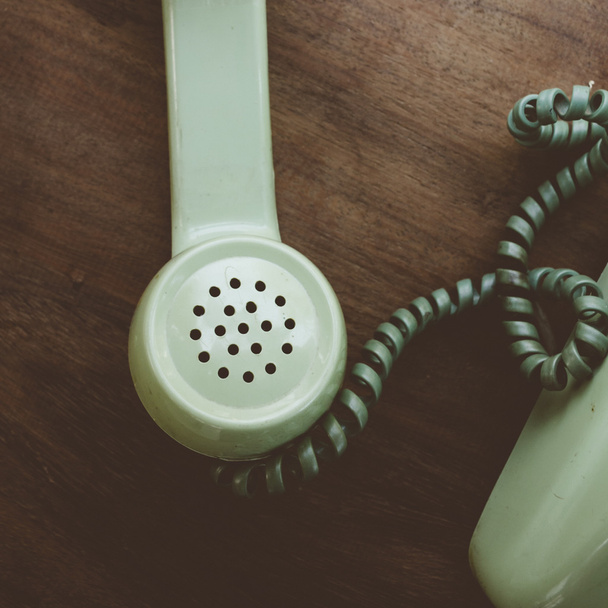 Téléphone vintage vert sur fond de bureau en bois brun
 - Photo, image