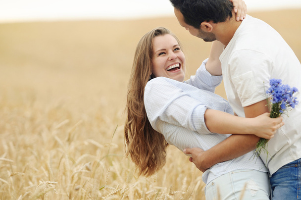夏の畑で楽しんで幸せな若いカップル - 写真・画像