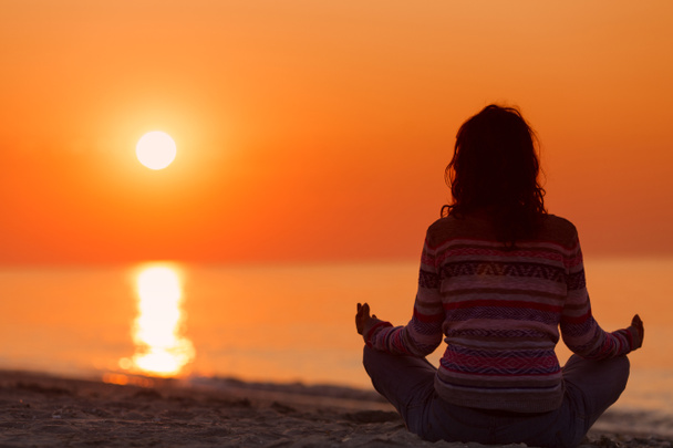 Silhouette einer Frau in Yoga-Lotus-Meditationsposition von vorne nach hinten - Foto, Bild