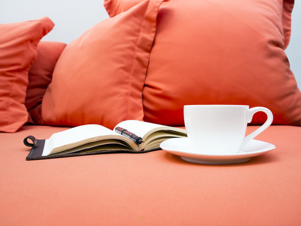 Кофе и книга на диване с украшением подушки
 - Фото, изображение