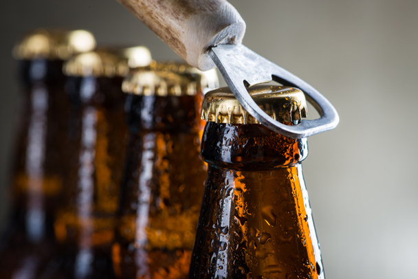Bottiglie di birra ghiacciata marrone con vecchio apriscatole
 - Foto, immagini