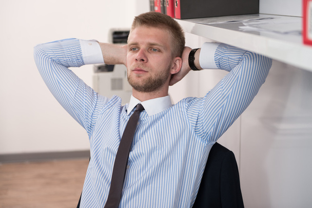 Young Businessman Relaxes Sitting In The Office - Foto, afbeelding