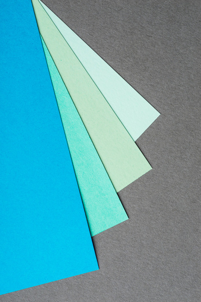 Mavi ve yeşil renk kağıt sayfalarının gri arka plan üzerinde - Fotoğraf, Görsel