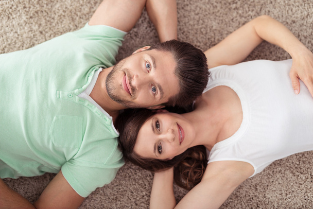 Sweet Couple Lying on Carpet, Looking at Camera - Foto, Imagem