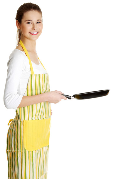 Smiling female teen with a frying pan. - Foto, Imagen