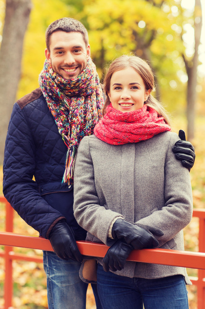 smiling couple hugging on bridge in autumn park - Photo, Image