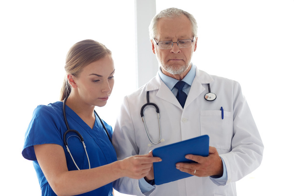 senior doctor and nurse with tablet pc at hospital - Photo, Image
