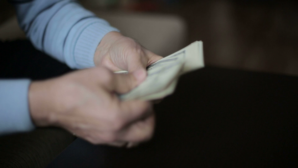 Podnikatel si ruce počítání sto dolarové bankovky, u stolu - Záběry, video