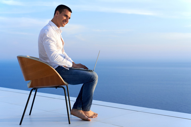 Entspannter junger Mann zu Hause auf Balkon - Foto, Bild