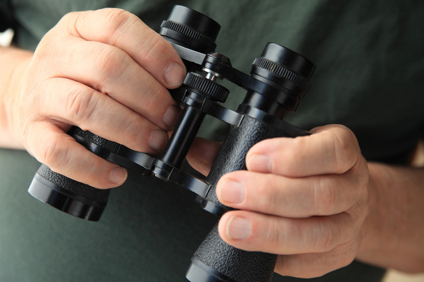 Man holds old pair of binoculars - Photo, image