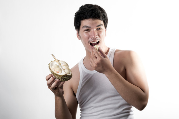 Азиатский мужчина ест дуриан
 - Фото, изображение