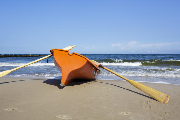 Спасательная шлюпка на морском пляже
 - Фото, изображение