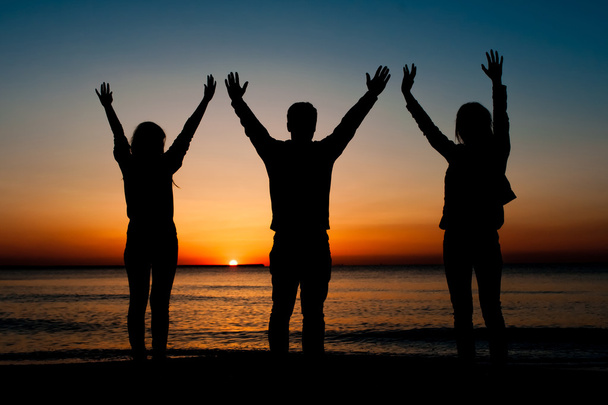 drie vrienden in de ochtend de lucht met handen ponsen - Foto, afbeelding