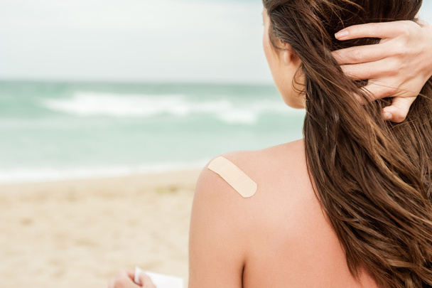 Vrouw op het strand met een band steun op haar bovenrug - Foto, afbeelding