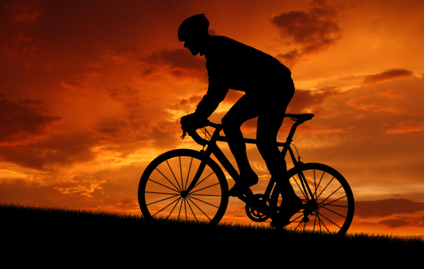 ποδηλάτης ιππασίας ένα ποδήλατο δρόμου στο ηλιοβασίλεμα - Φωτογραφία, εικόνα