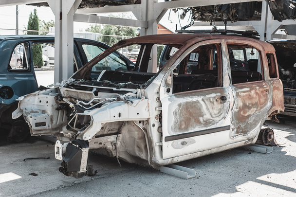 Verrostetes brennendes Auto im Abbruchhof. - Foto, Bild