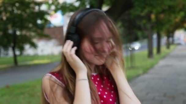 young girl enjoying music in headphones - Filmati, video