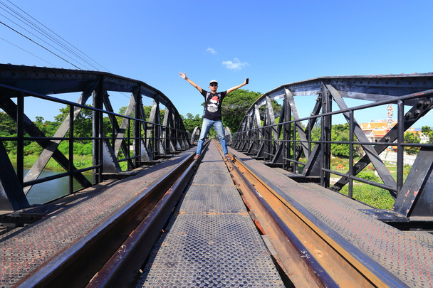 Hombre y puente sobre el río Kwai en Kanchanaburi en Tailandia
 - Foto, Imagen
