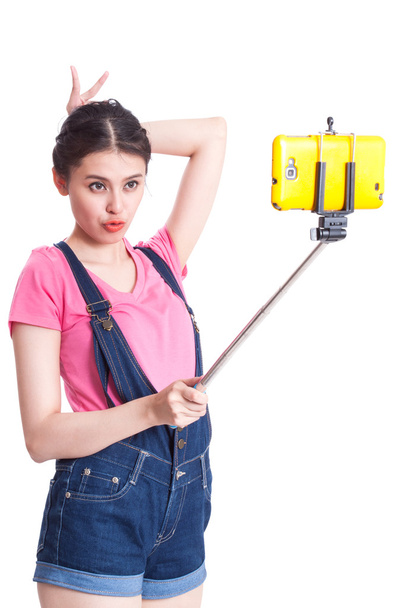 Happy woman taking picture with smartphone selfie stick - Foto, Imagem