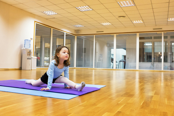 Kind, een meisje is betrokken bij het ballet, gymnastiek, yoga in de sportschool - Foto, afbeelding