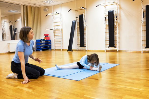 Ребенок, девушка занимается балетом, гимнастикой, йогой в тренажерном зале
 - Фото, изображение