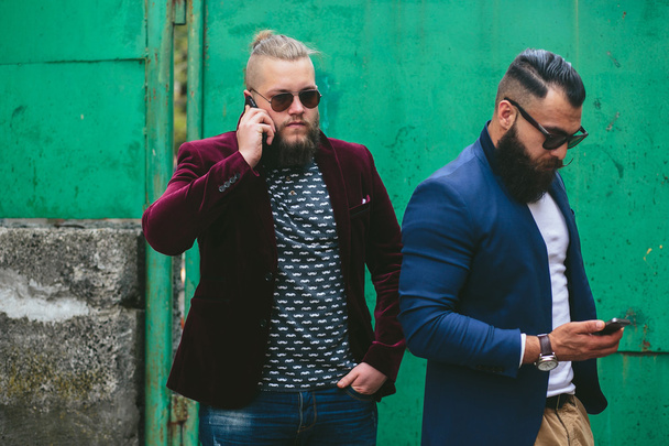 Two bearded businessman looking at phone - Foto, imagen