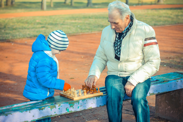 Дедушка и внук играют в шахматы
 - Фото, изображение